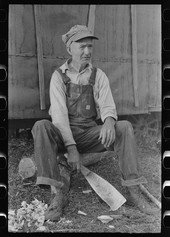 [Untitled photo, possibly related to: Day laborer with sugarcane knife in front of his shack home near New Iberia…