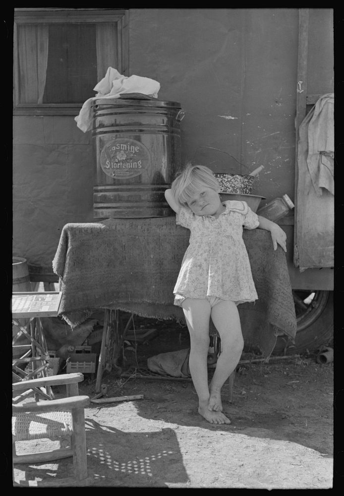 [Untitled photo, possibly related to: Child of migrant family in front of household goods of trailer home, Weslaco, Texas]…