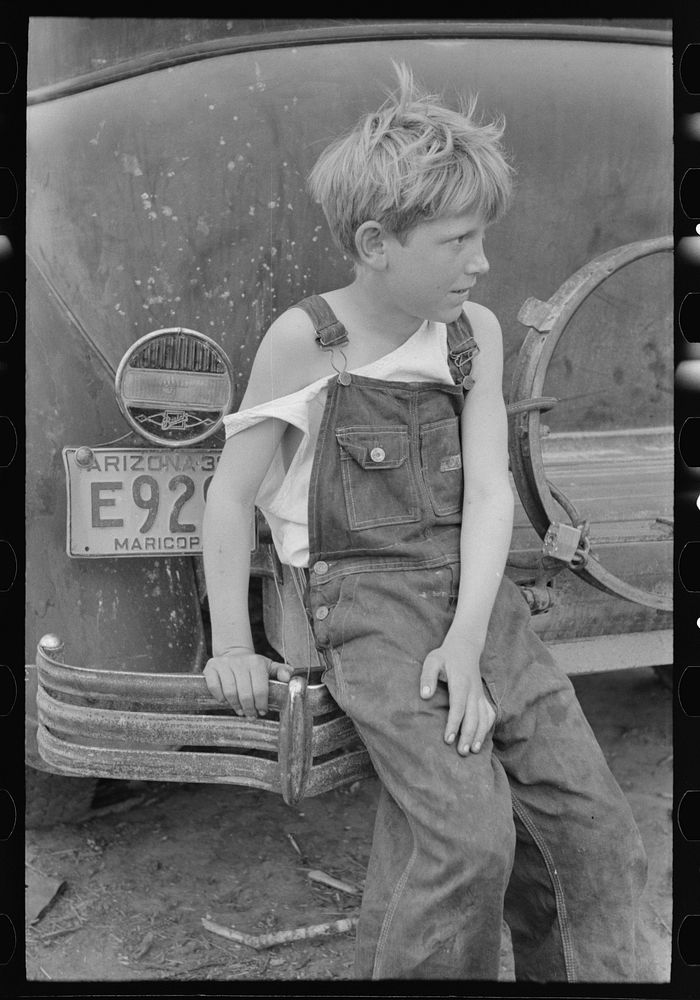 Child of  migrant worker sitting on bumper of their car from Arizona, near Harlingen, Texas by Russell Lee