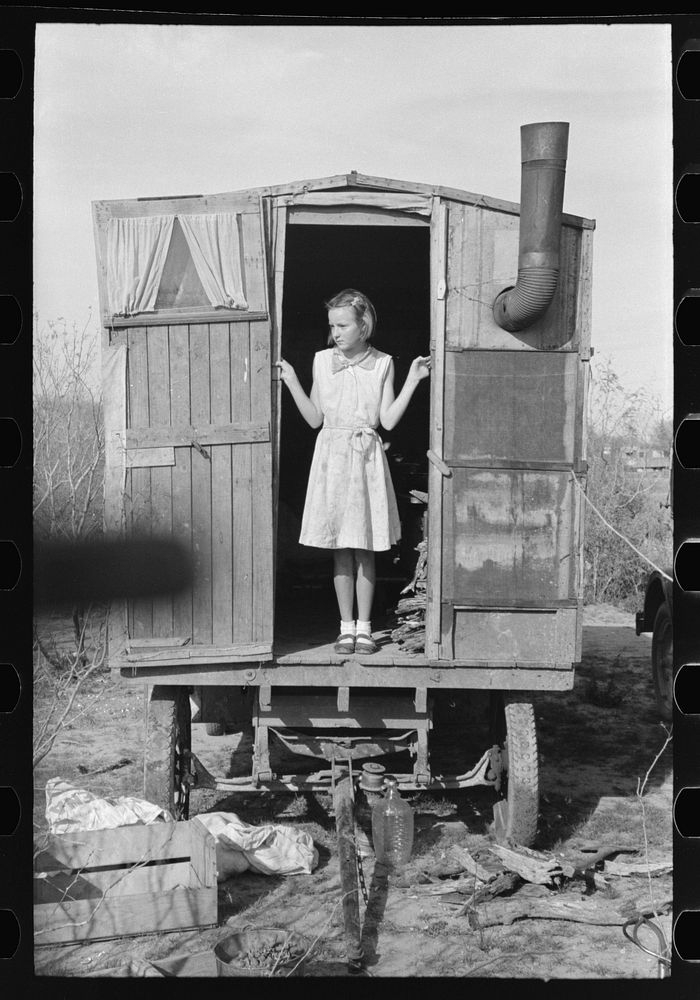 Daughter of migrant in doorway of trailer, Sebastin, Texas by Russell Lee