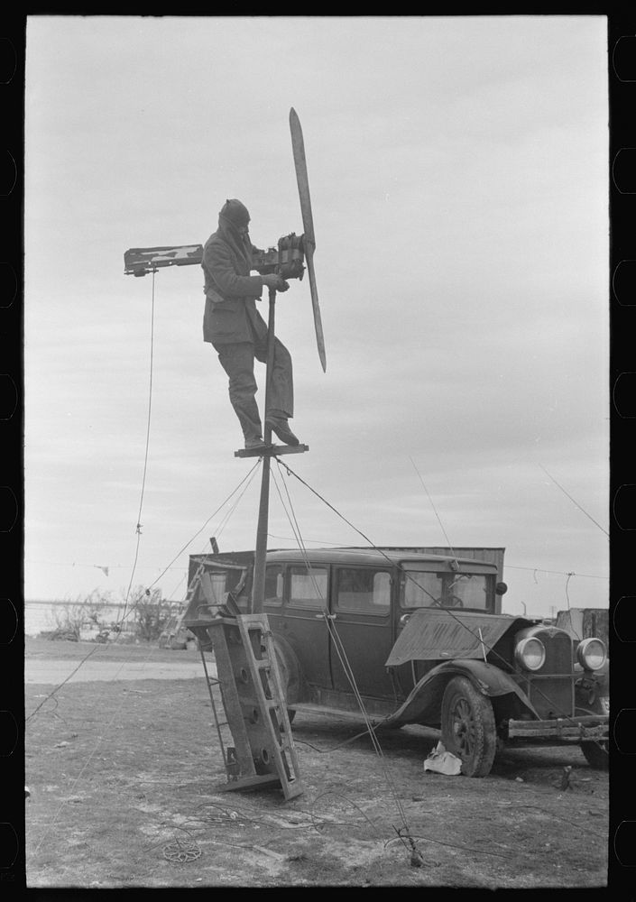 Shrimp fisherman, squatter on Nueces Bay, erecting wind charger for running his radio. Corpus Christi, Texas by Russell Lee