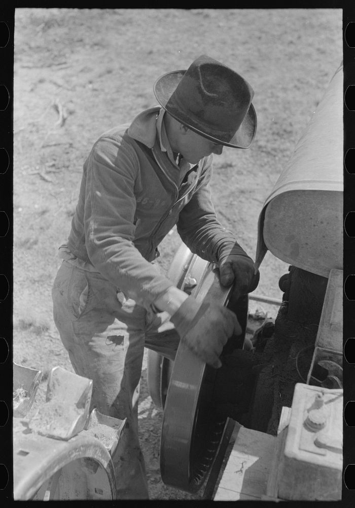[Untitled photo, possibly related to: Starting a tractor by starting the flywheel, El Indio, Texas] by Russell Lee