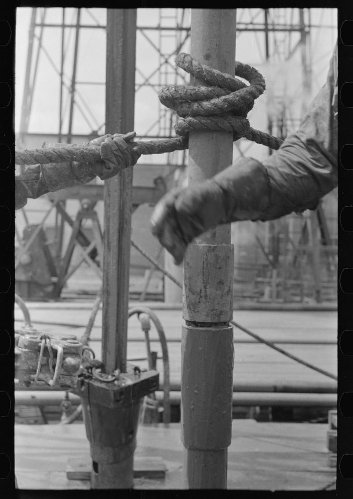 [Untitled photo, possibly related to: Detail of screwing one pipe into another. Oil field drilling operations, Kilgore…