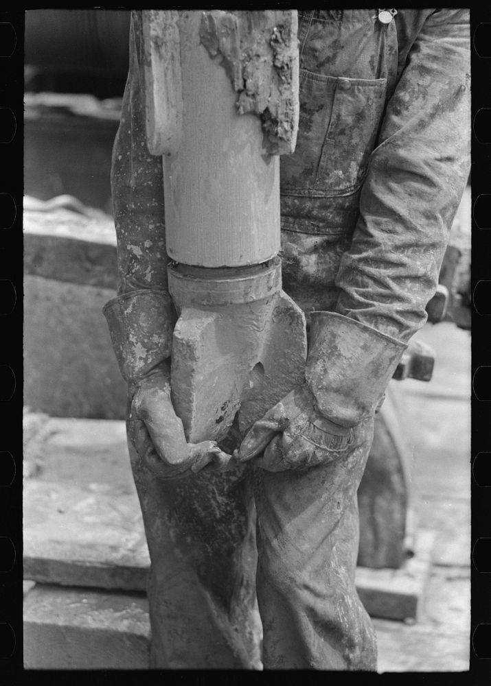 Screwing on the bit. Hole through which mud is forced from the mud hog may be seen in the bit. Oil well, Kilgore, Texas by…