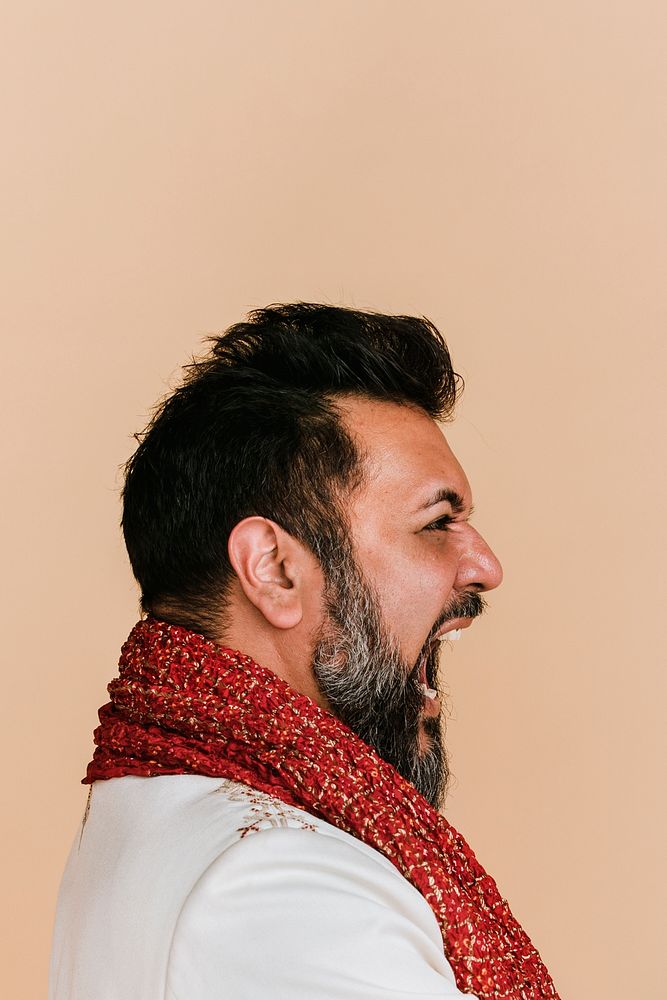 Angry Indian man wearing a kurta with a red scarf 