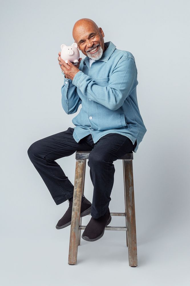 Happy retired man holding his piggy bank