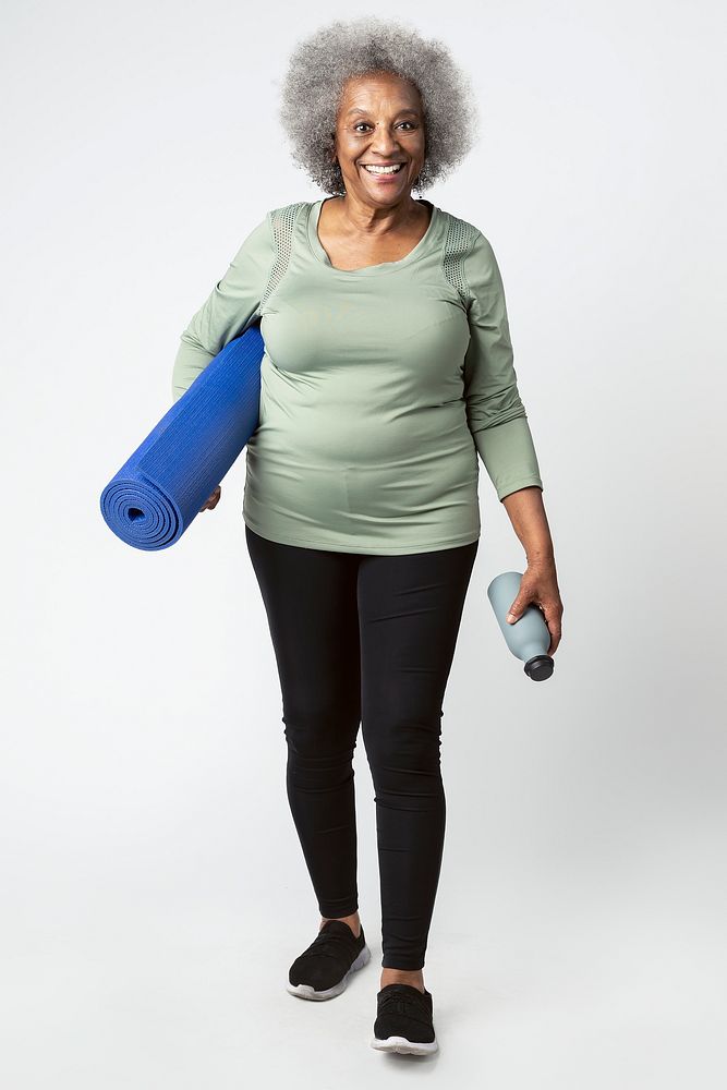 Happy black senior woman with a yoga mat and a water bottle
