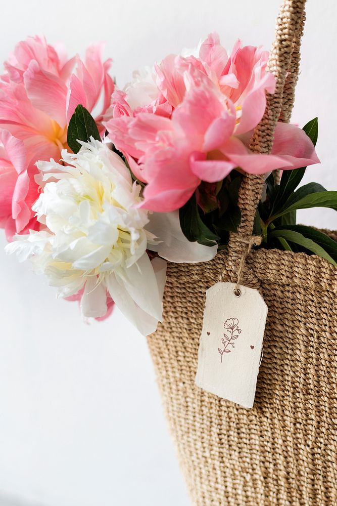 Beautiful peonies in a wicker bag with a white tag mockup