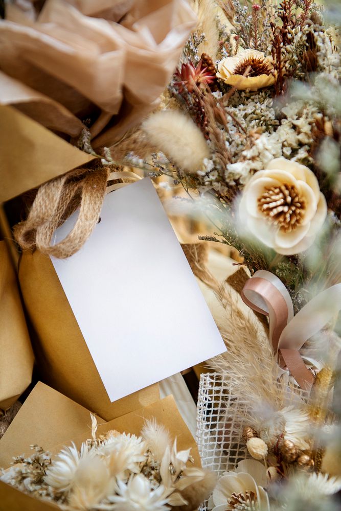 Blank white card on a bouquet of dry poppies