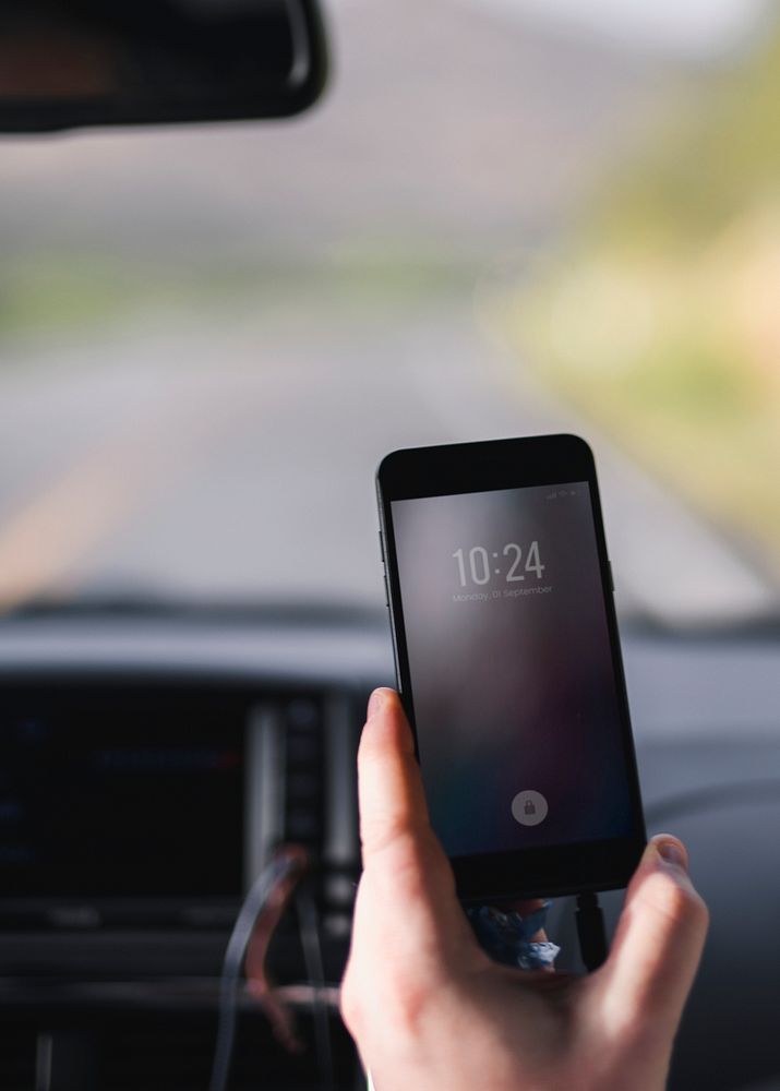 Man checking a time from his phone inside a car