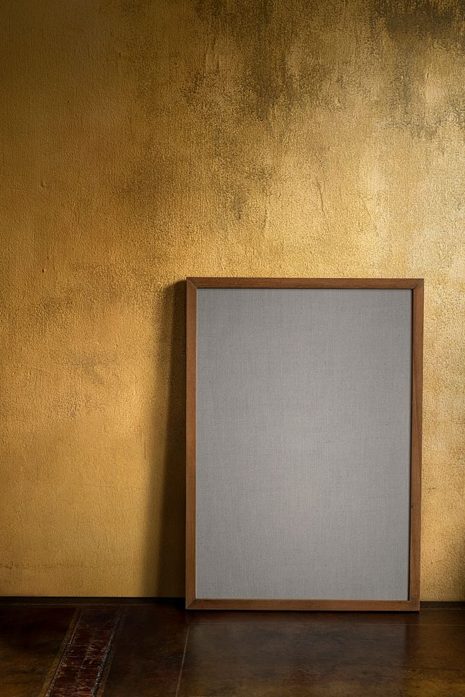 Blank wooden frame mockup by a grunge yellow wall