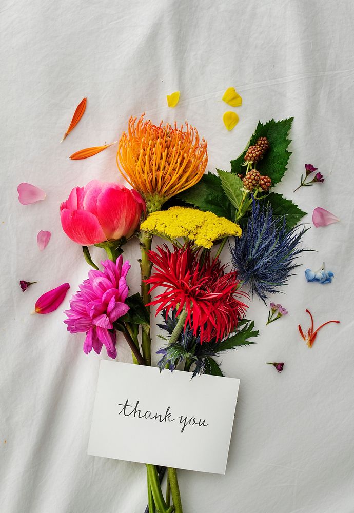 Bouquet of colorful flowers on a white bed sheet with a card mockup