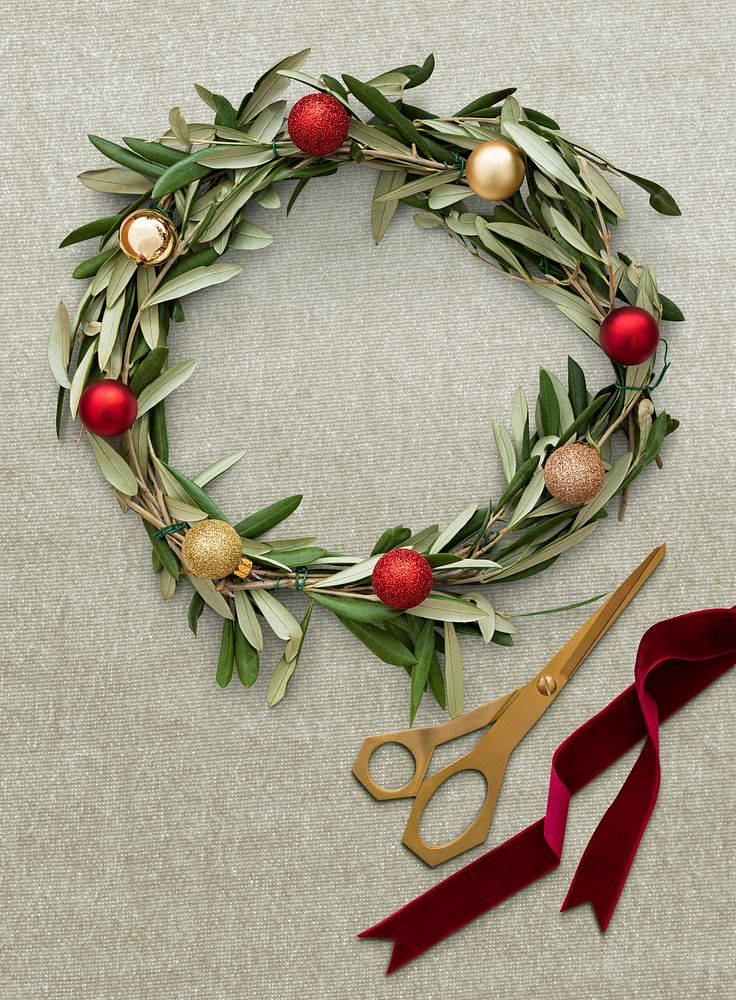 Flat lay of Christmas DIY wreath decoration on a light green background