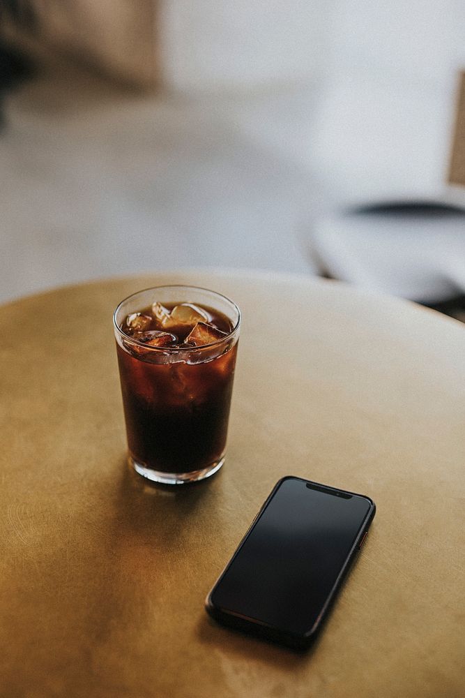Iced coffee and a phone on a table