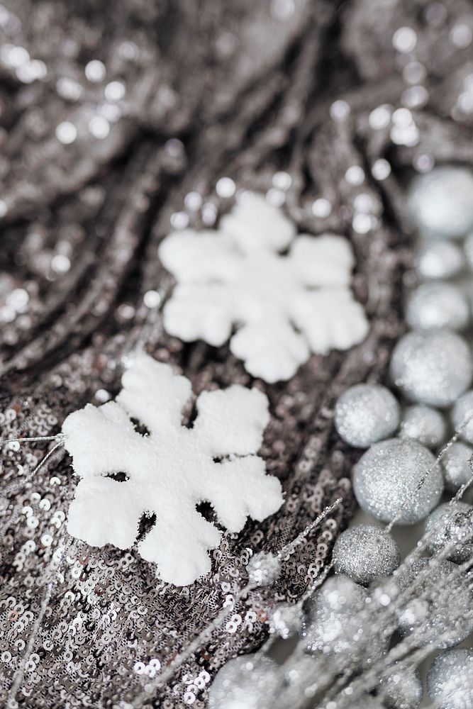 White snowflake ornament on silver sequin background