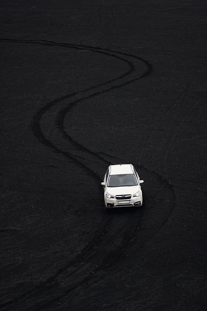 Car driving on black sand beach in Iceland