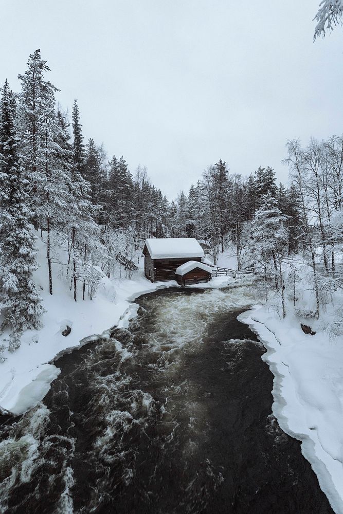 Snow-covered hut by  river in the Oulanka National Park, Finland