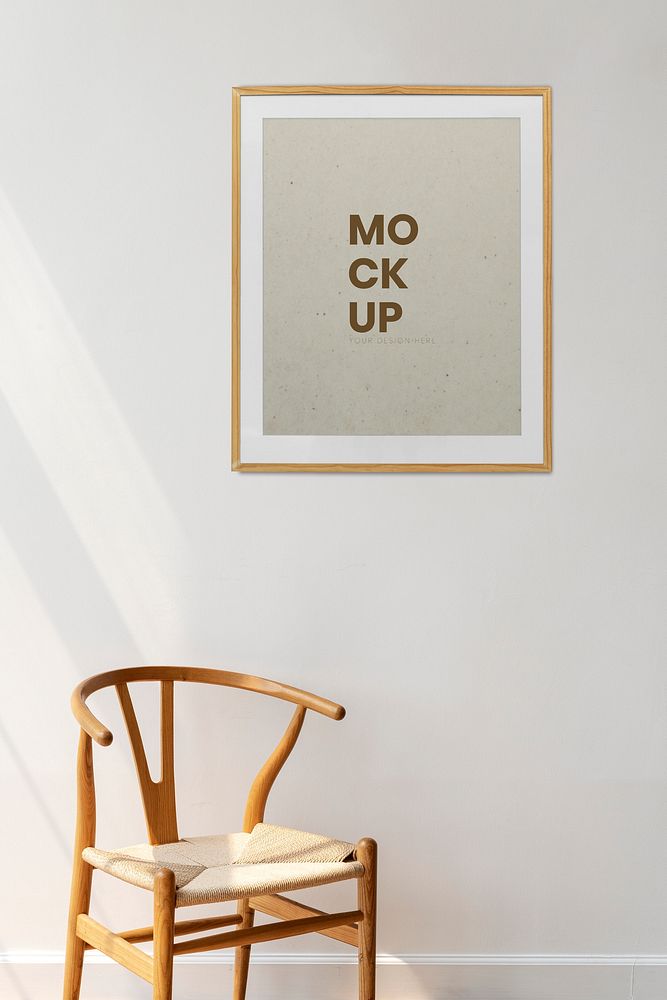 Picture frame mockup hanging above a classic wooden chair