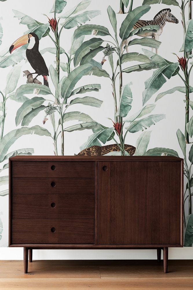 Mid century modern wood cabinet by a leafty wall