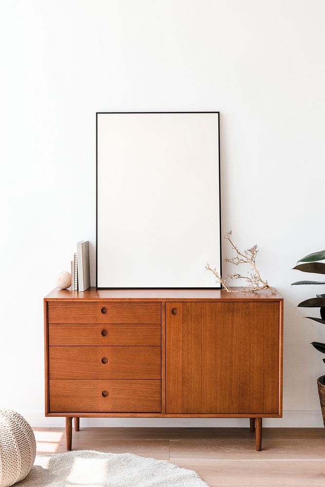 Blank picture frame on a wooden cabinet