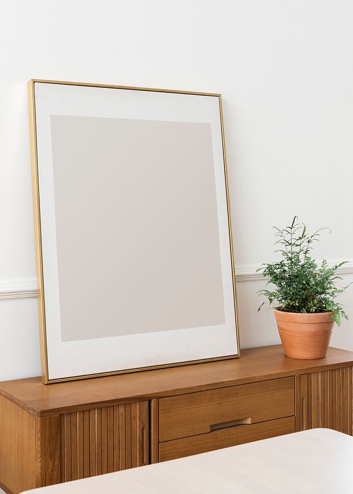 Blank picture frame on a wooden cabinet