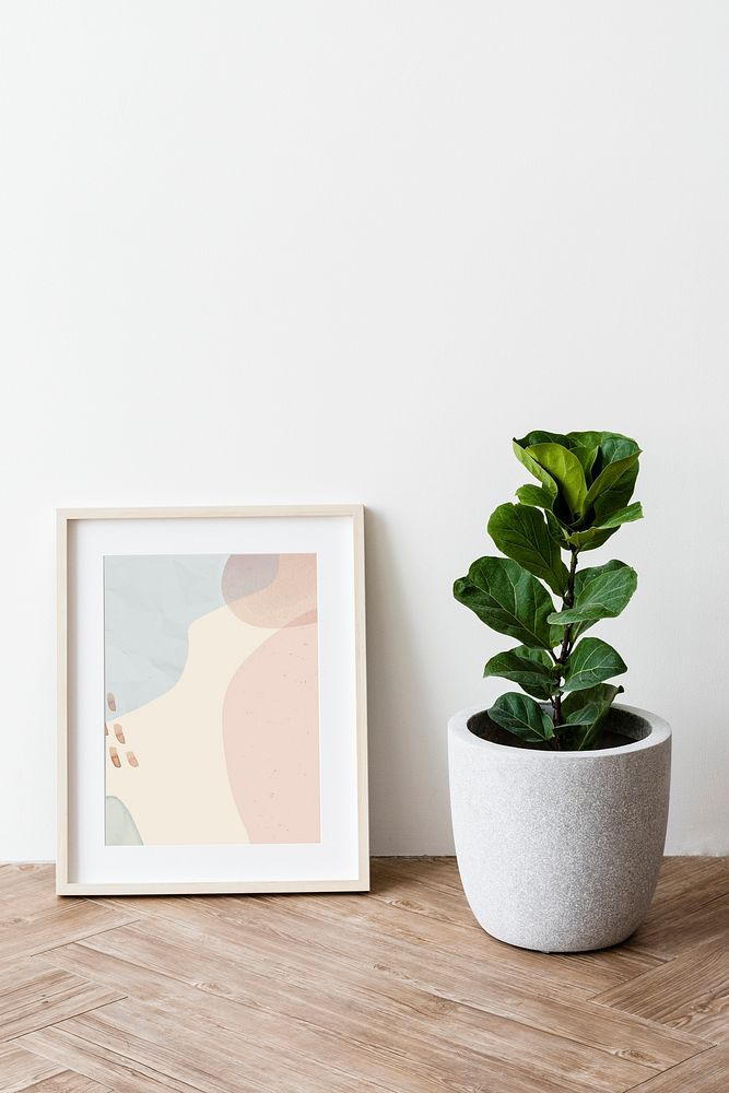 Picture frame mockup by a fiddle-leaf fig plant on a parquet floor