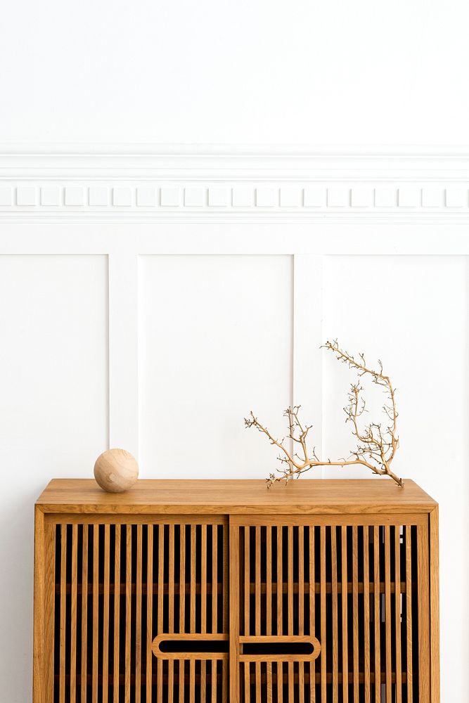 Dry twig on a wooden cabinet in a white room