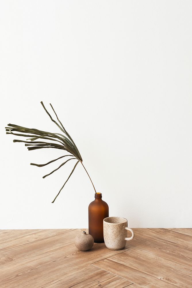 Minimal coffee cup by a brown vase on wooden floor