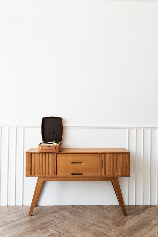 Vinyl player in a portable turntable on a wooden sideboard table