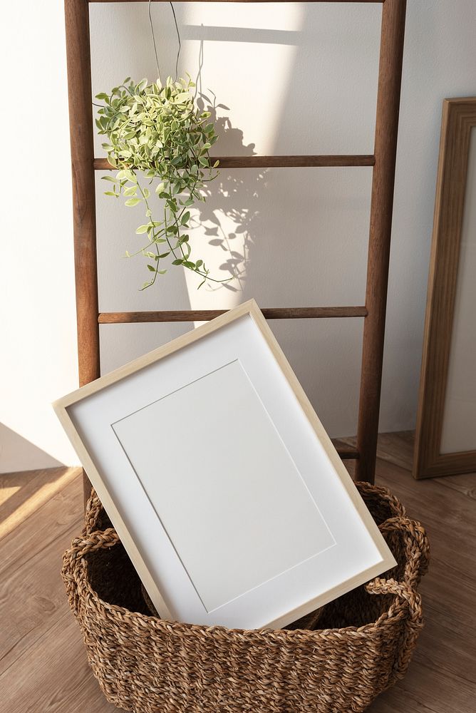 Picture frame in a wicker basket by a wooden ladder 