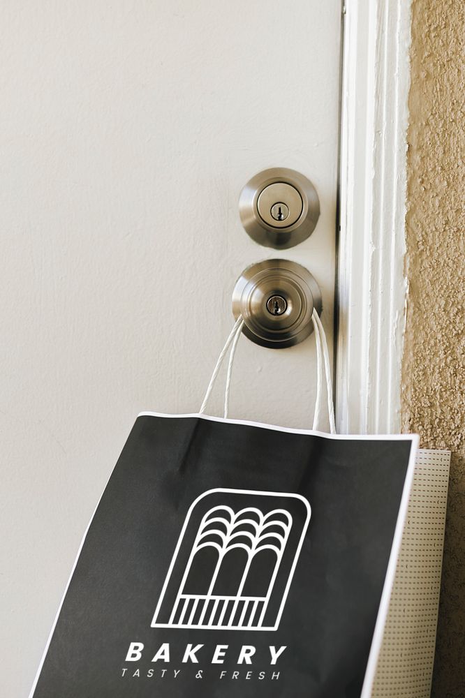 Contactless delivery bakery paper bag mockup hanging on a doorknob during the coronavirus pandemic