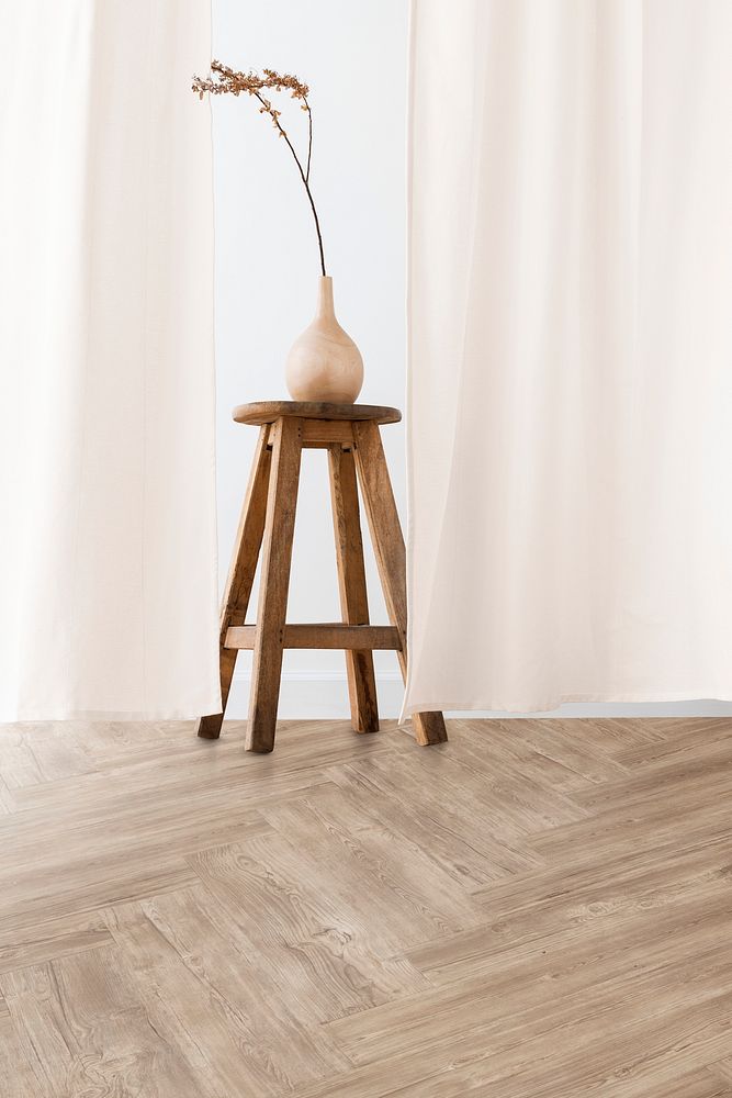 Dry Forsythia branch in a wooden vase on a stool by a beige curtain