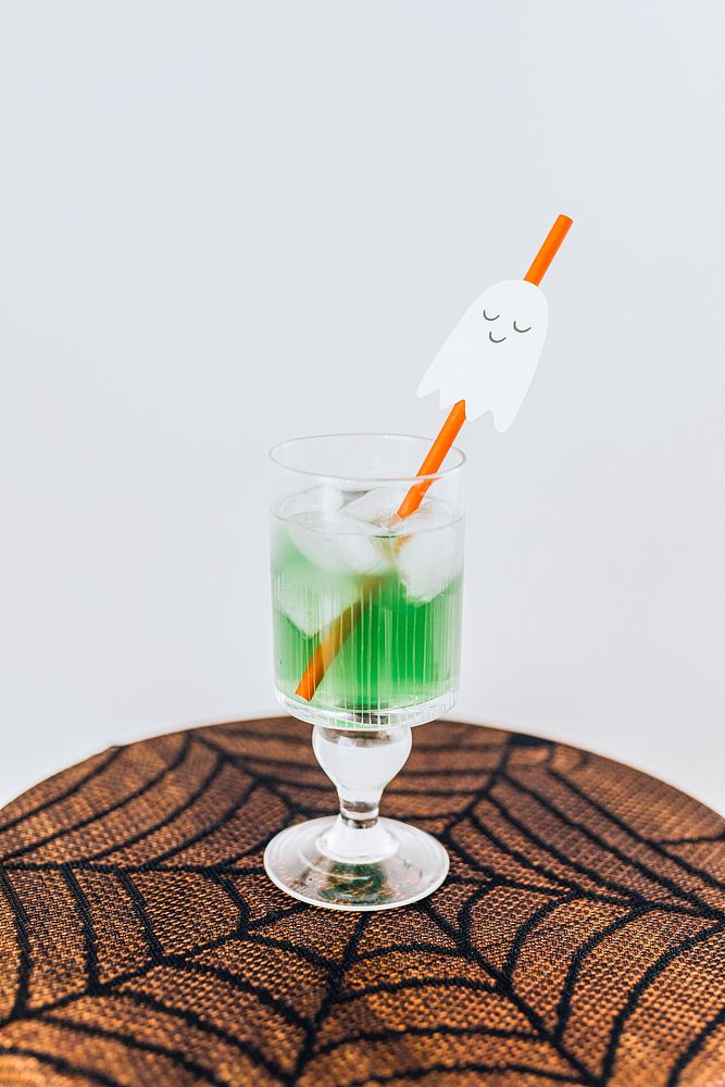 Halloween drink with a ghost straw on a spider web lace tablecloth 