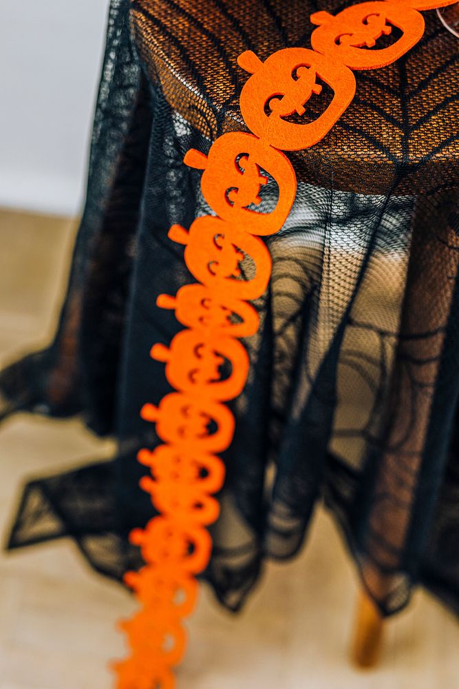 Orange pumpkin garland on a black lace tablecloth 