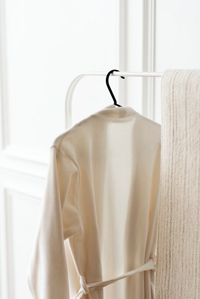 White bathrobe hanging on a clothing rack