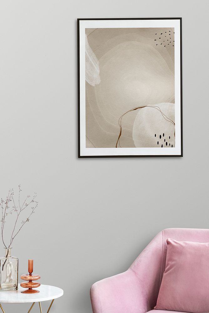 Picture frame with abstract art by a pink velvet armchair