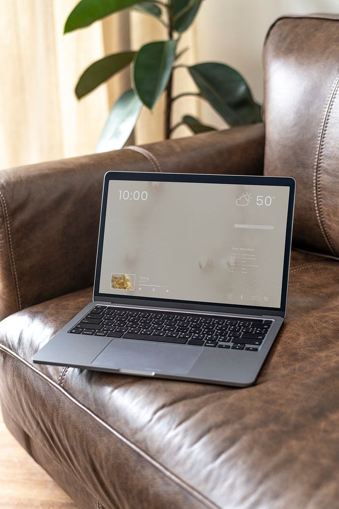 Laptop screen psd mockup on a leather couch