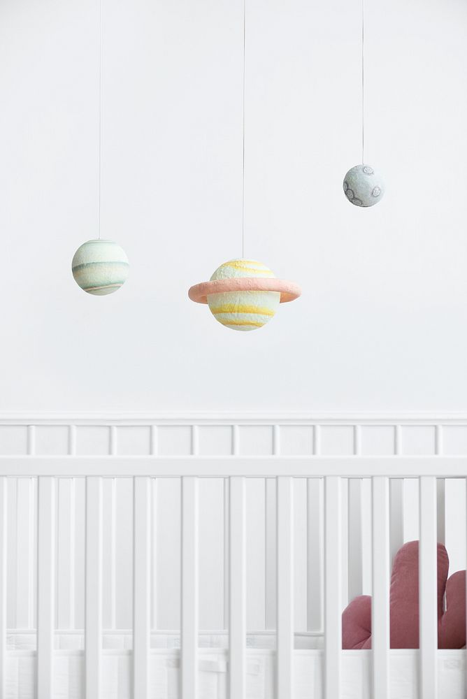 Planetary mobile above a white crib