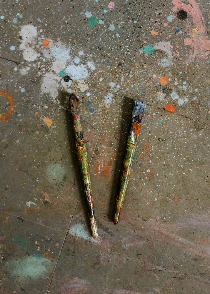 Two paint brush on the floor with paint drop 