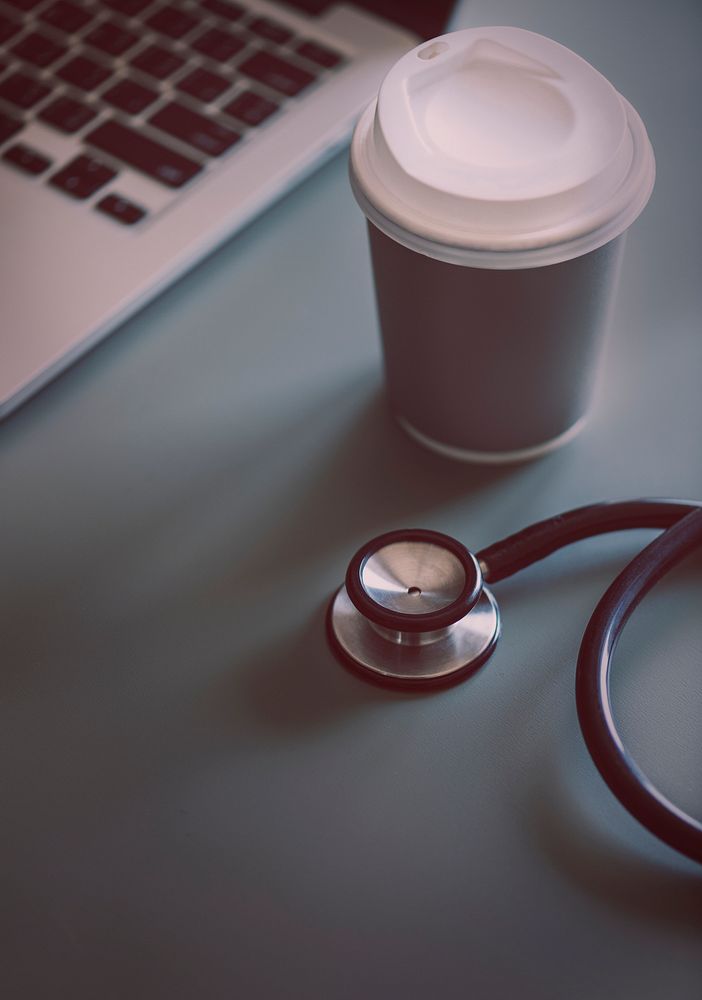 Closeup of doctor stethoscope with coffee paper cup