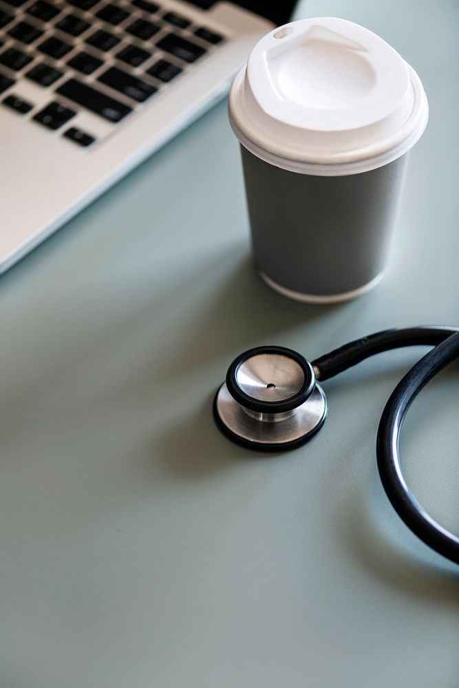 Closeup of doctor stethoscope with coffee paper cup