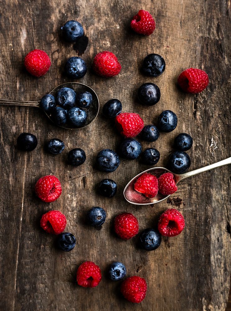 Fresh raspberries and blueberries on a wooden table