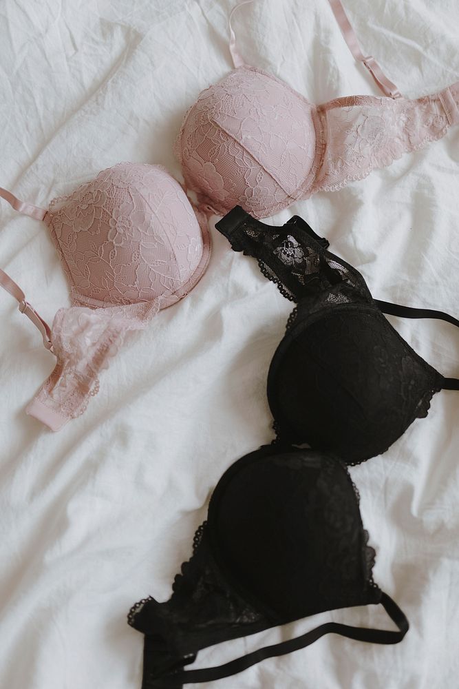 Pink and black bras on a bed