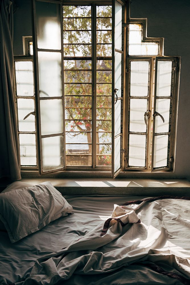 Daylight shining through an unmade bed