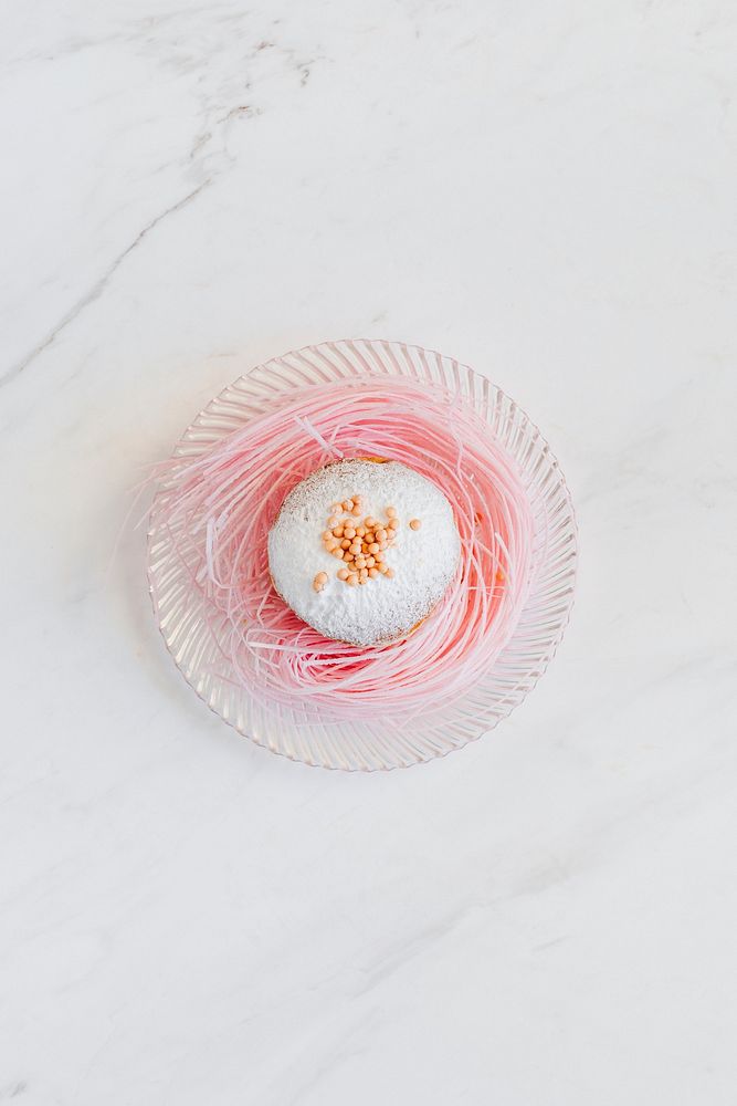 White glaze donut on a pink sugar nest
