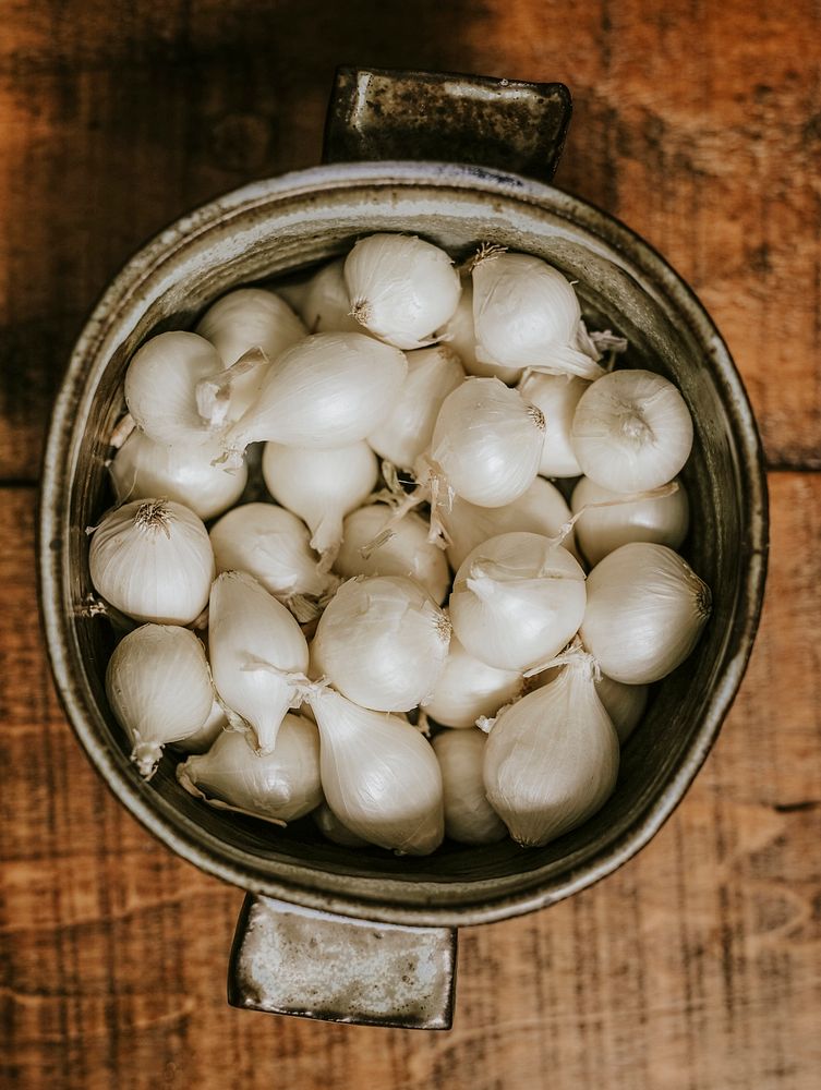 Raw white onions in a pot