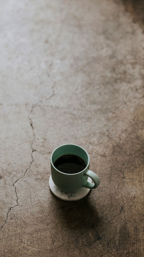 Hot cup of coffee on concrete floor mobile phone wallpaper