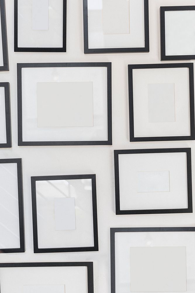 Various blank photo frames on white wall