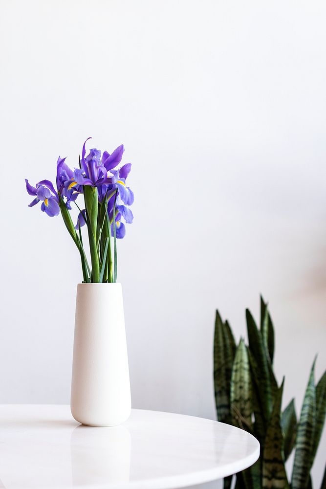 Purple flower in a white vase on the table
