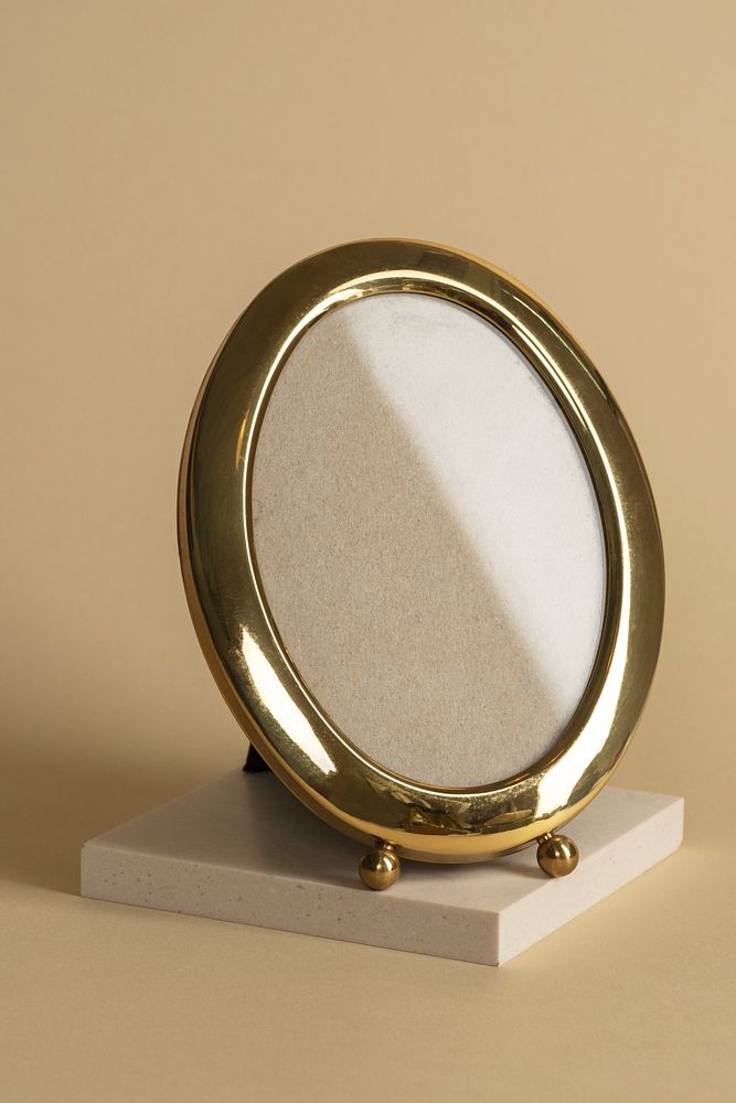 Oval gold photo frame on beige background